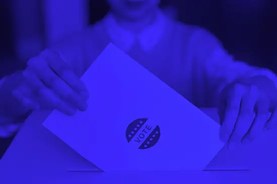 Blue photo of someone submitting a ballot