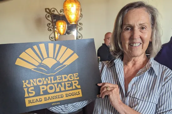 Woman holding a sign that says Knowledge is power, read banned books