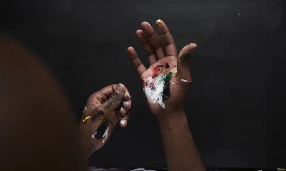 Artist's hands covered in paint