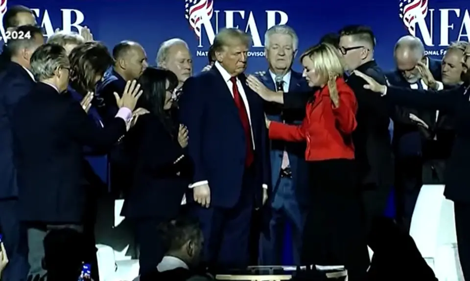 A group of religious-right leaders lay hands on Trump and pray for him at a "national faith summit" sponsored by Paula White's National Faith Advisory Board. 