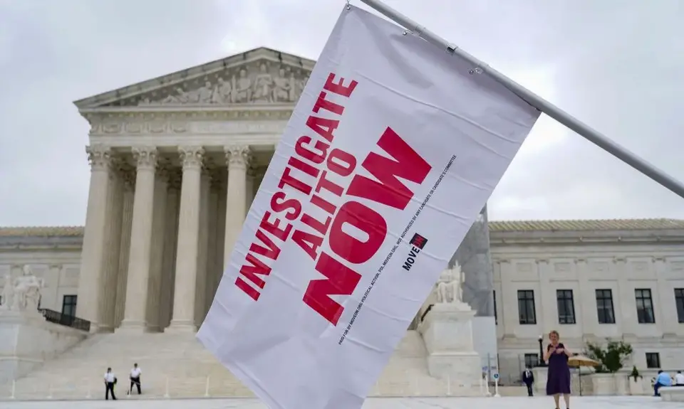 A flag for the investigation of Justice Alito is waved at an event outside the Supreme Court in Washington, D.C.