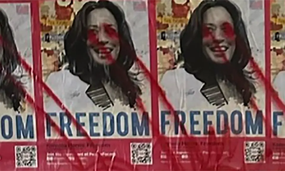 Posters of Kamala Harris with the word "Freedom" covered it red spray paint