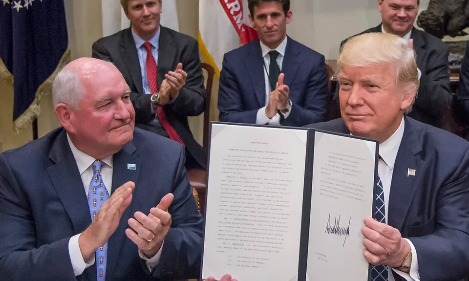 Agriculture Secretary Sonny Perdue with Trump holding up a signed executive order.