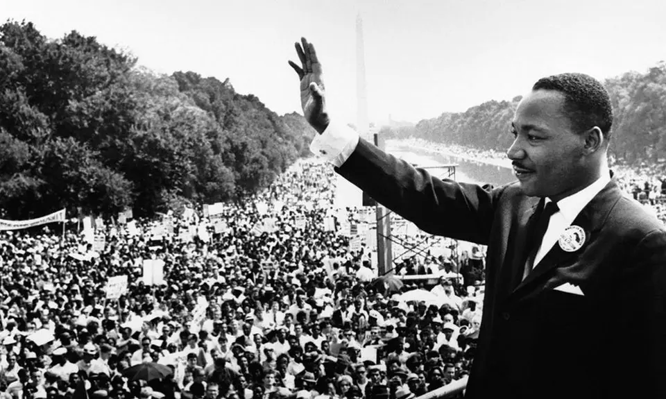 A photo of Dr. Martin Luther King Jr. waving to a crowd at the national mall.