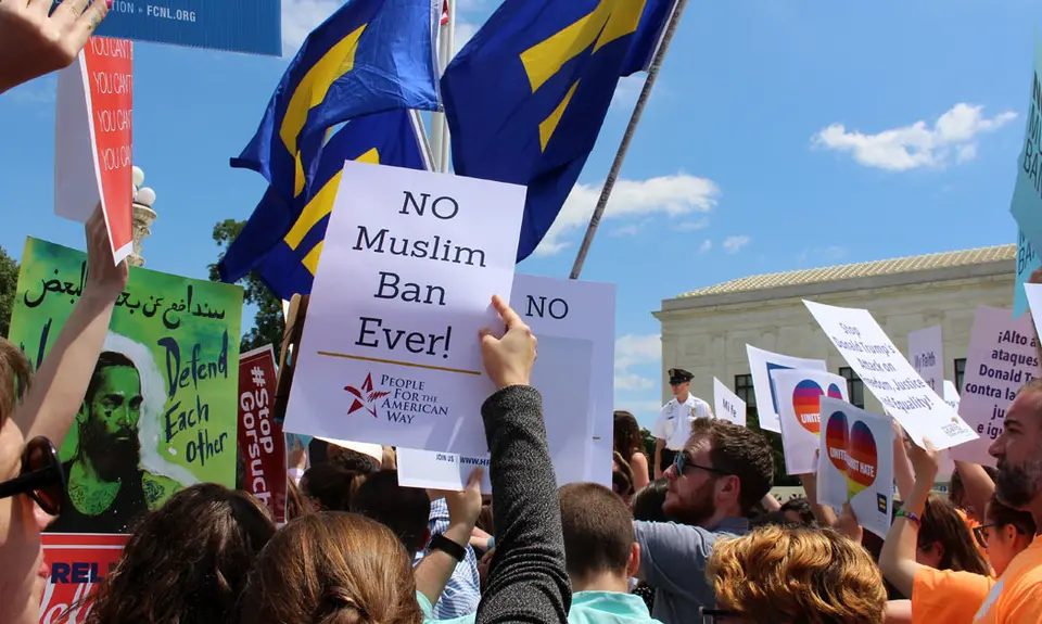 Woman holding "no muslim ban ever!" sign at rally