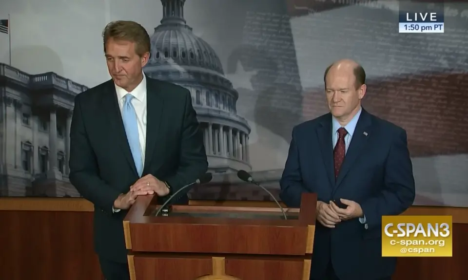 Jeff Flake and Chris Coons stand at a podium