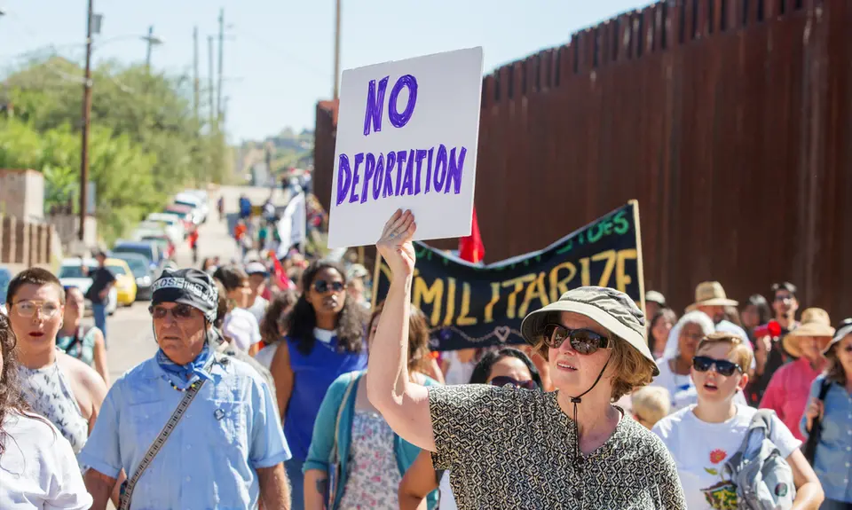 Activists walk along the U.S.-Mexico border to protest deportation.