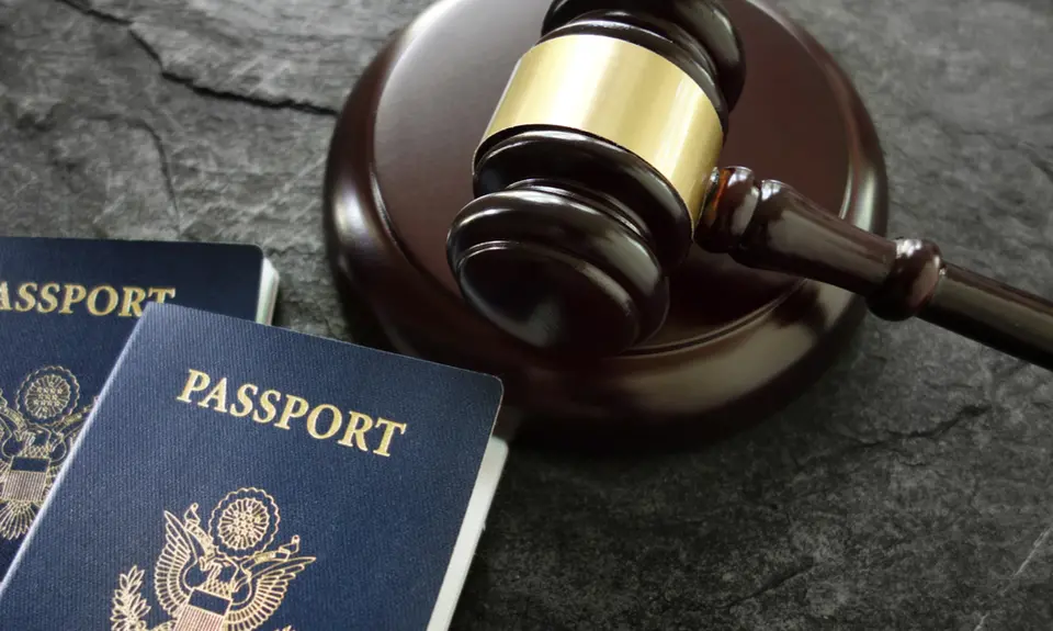 A gavel sits next to two American passports