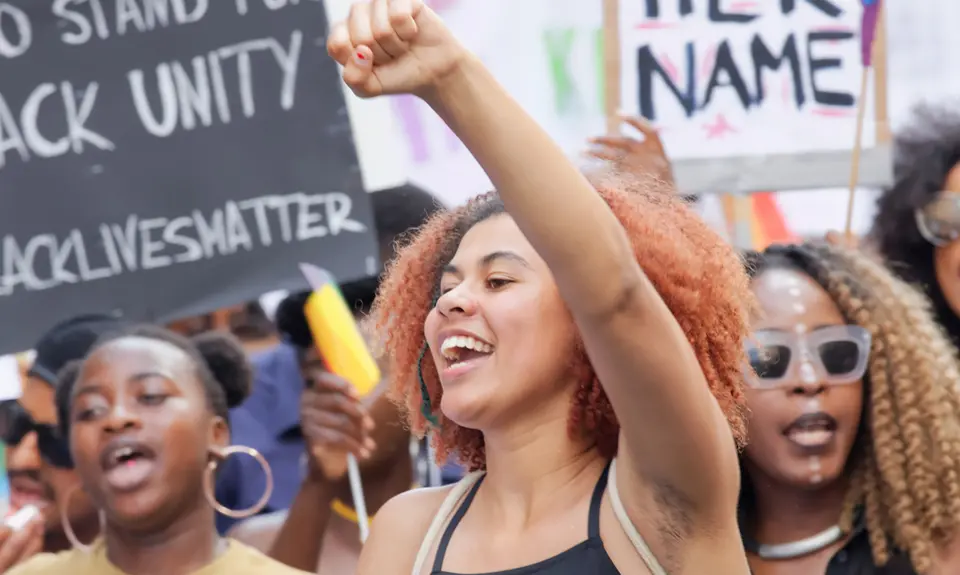 A group of Black women holding signs in favor of Black Lives Matter