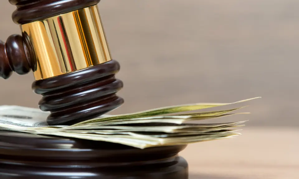 A gavel resting on a stack of money