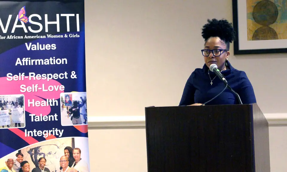 Lauren Wilson speaks from behind a podium at the 2019 spring VASHTI Convocation