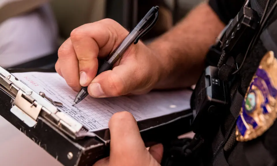 A close up of a police officer writing a ticket