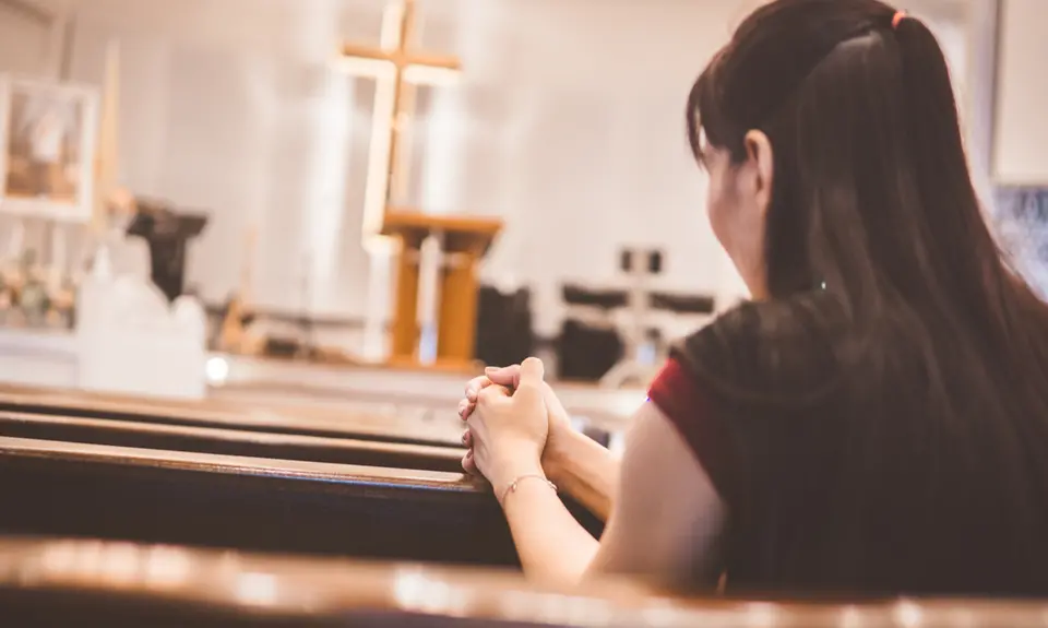 A woman prays in a church