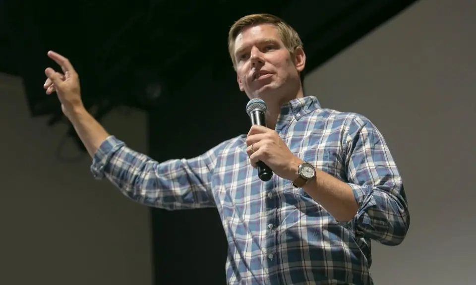 Democratic presidential candidate Eric Swalwell wearing a blue plaid shirt and answering a question