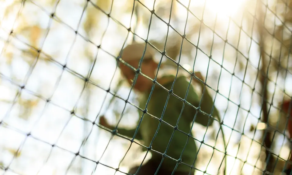 A child jumps rope behind a net