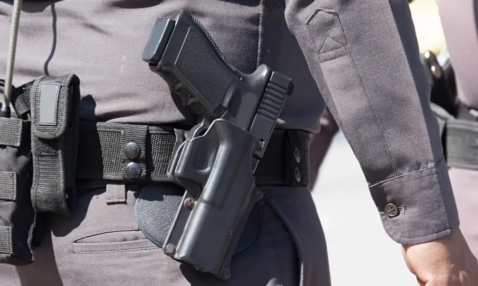 Close up of the gun on a police officer's belt