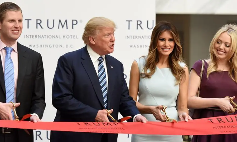 Donald Trump with his wife and children cutting the ribbon on Trump hotel.