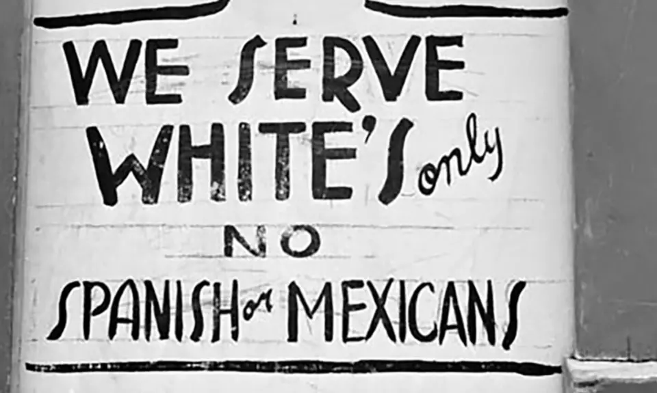 An old sign with the text "We serve white's only. No Spanish or Mexicans."