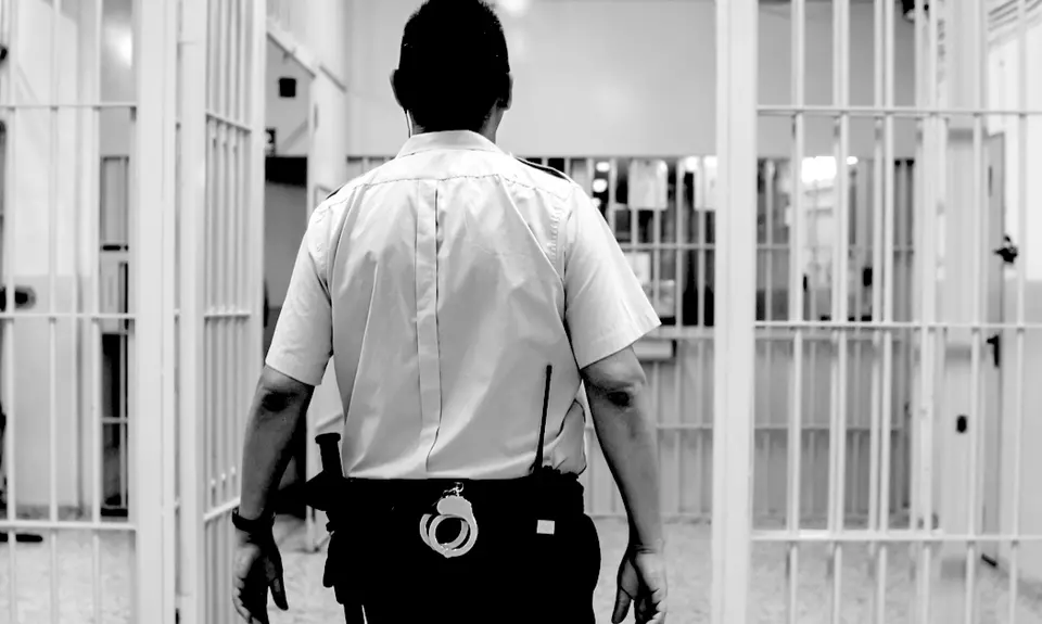 A prison guard walks through the hallways of a prison.