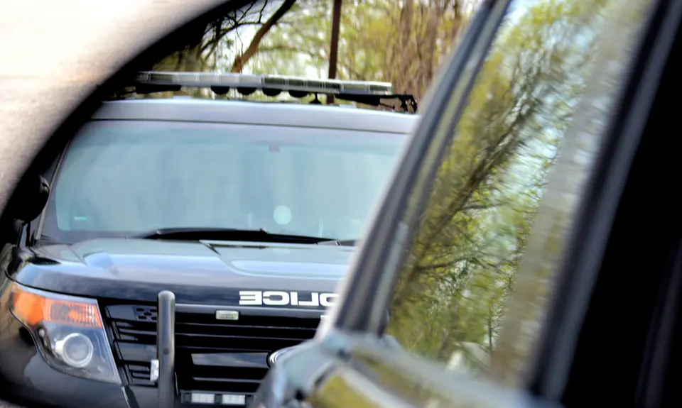 An image of a police SUV in another car's side mirror.