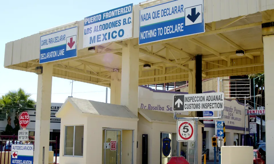 A border control checkpoint with signs in both English and Spanish