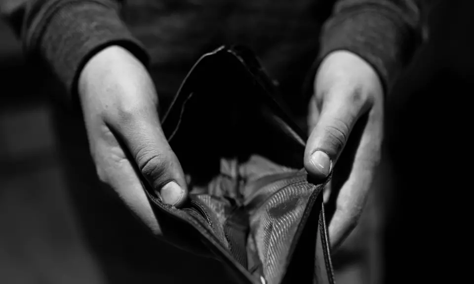 A person holds open an empty wallet