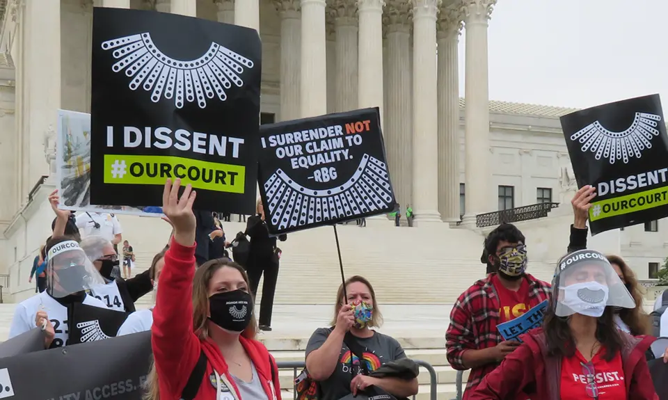 Activists hold signs that read "I Dissent #OurCourt" in front of the Supreme Court.