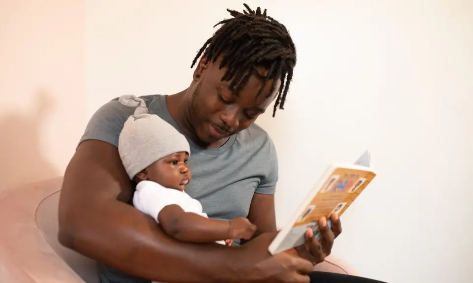 Black father reading to child