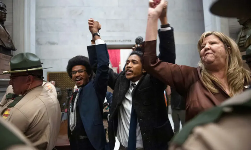 Rep. Justin Pearson, Rep. Justin Jones, Rep. Gloria Johnson People hold their hands up as they exit the House Chamber doors at the Tennessee State Capitol Building