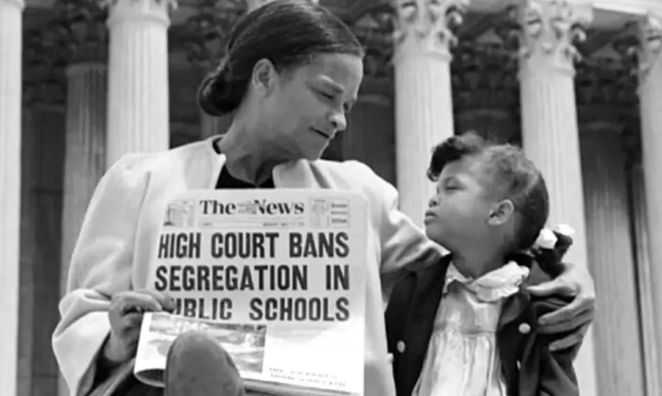 A woman and girl in front of the Supreme Court with a newspaper reading "High Court Bans Segregation in Public Schools"