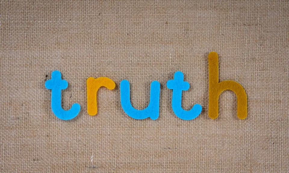 The word "truth" in colorful tiles on a beige background.