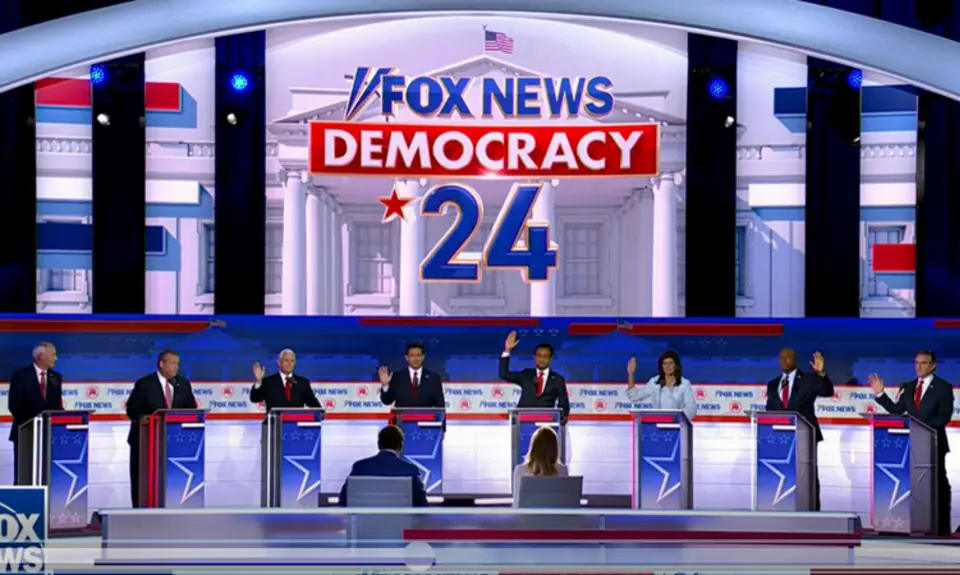 GOP presidential candidates raising their hands behind podiums at the GOP debate.