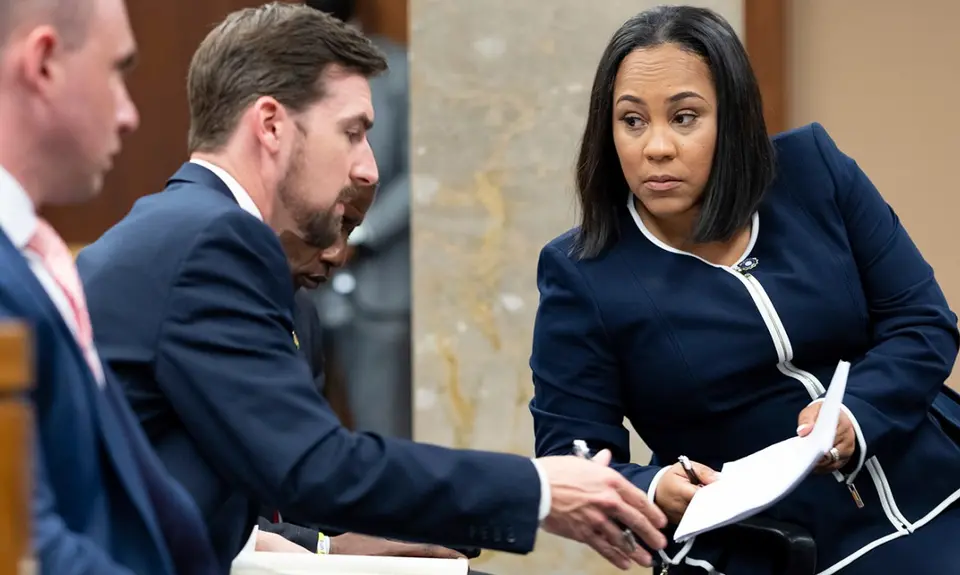 Fulton County District Attorney Fani Willis, right, talks with a member of her team during proceedings to seat a special purpose grand jury in Fulton County, Georgia, on May 2, 2022, to look into the actions of former President Donald Trump and his supporters who tried to overturn the results of the 2020 election. (AP Photo/Ben Gray, File)