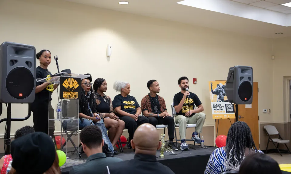 4 panelists on a stage at a Black History Month event.