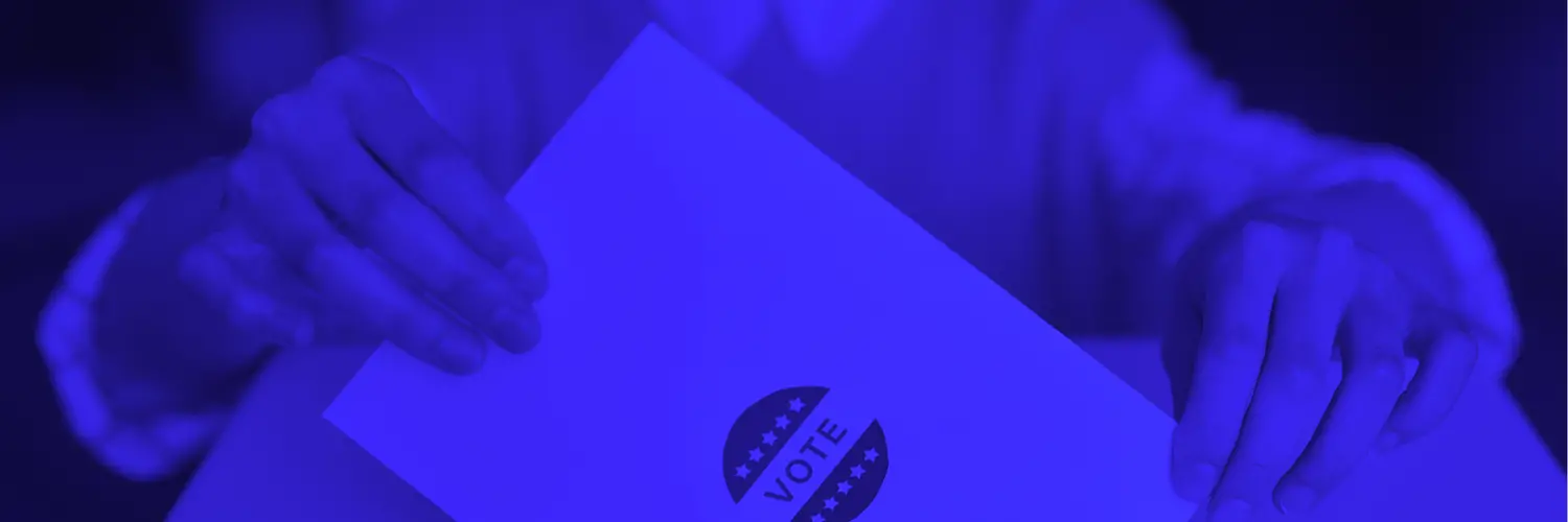 Blue photo of someone submitting a ballot