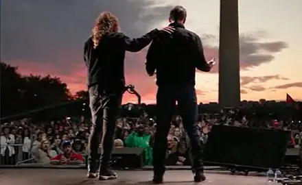 Photo from behind Sean Feucht and Josh Hawley with crowd in front of them and Washington monument behind the crowd. 