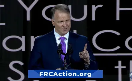 Center for Judicial Renewal's Phillip Jauregui speaks on stage at Pray Vote Stand conference at lectern that has placard reading "FRCAction.org"