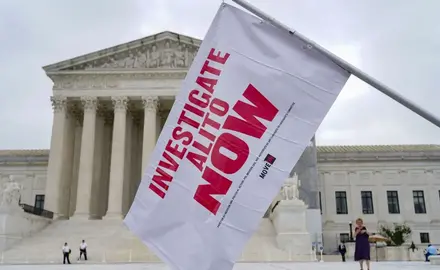 A flag for the investigation of Justice Alito is waved at an event outside the Supreme Court in Washington, D.C.