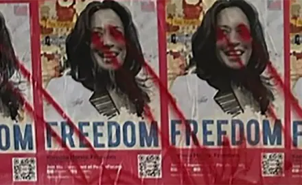 Posters of Kamala Harris with the word "Freedom" covered it red spray paint