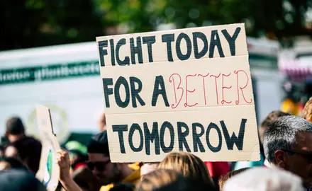 Protesters holding a sign that reads "fight today for a better tomorrow"