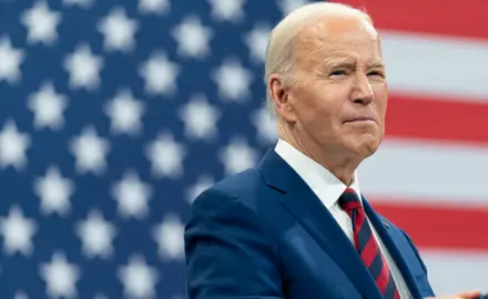 President Biden in front of an American flag.