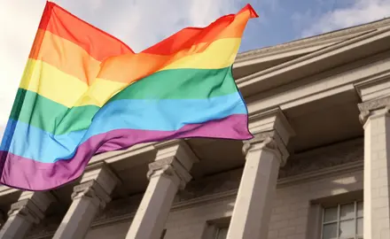 A rainbow flag in front of a building.