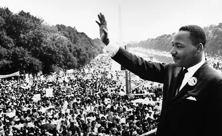 A photo of Dr. Martin Luther King Jr. waving to a crowd at the national mall.