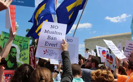 Woman holding "no muslim ban ever!" sign at rally