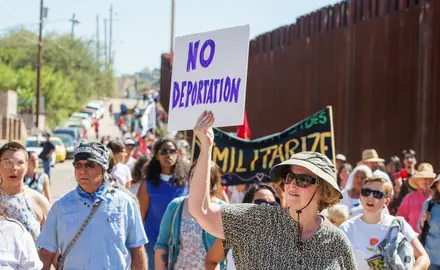 Activists walk along the U.S.-Mexico border to protest deportation.