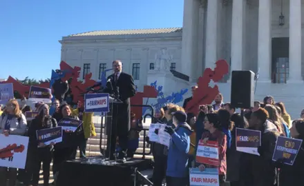 People hold signs at a voting rally