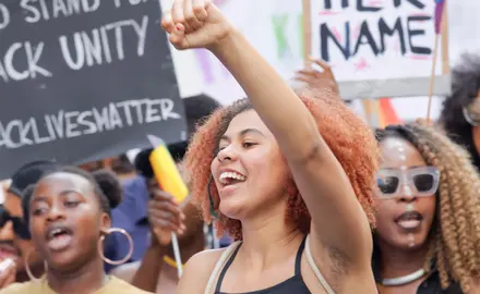 A group of Black women holding signs in favor of Black Lives Matter