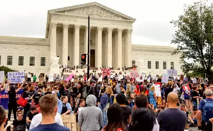 A group of people rallies outside of the Supreme Court