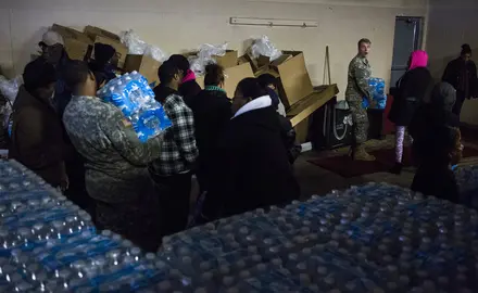 Members of the Michigan National Guard distribute bottled water to residents.