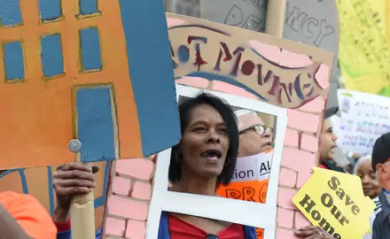 Activists march across the Brooklyn Bridge holding signs demanding affordable housing.